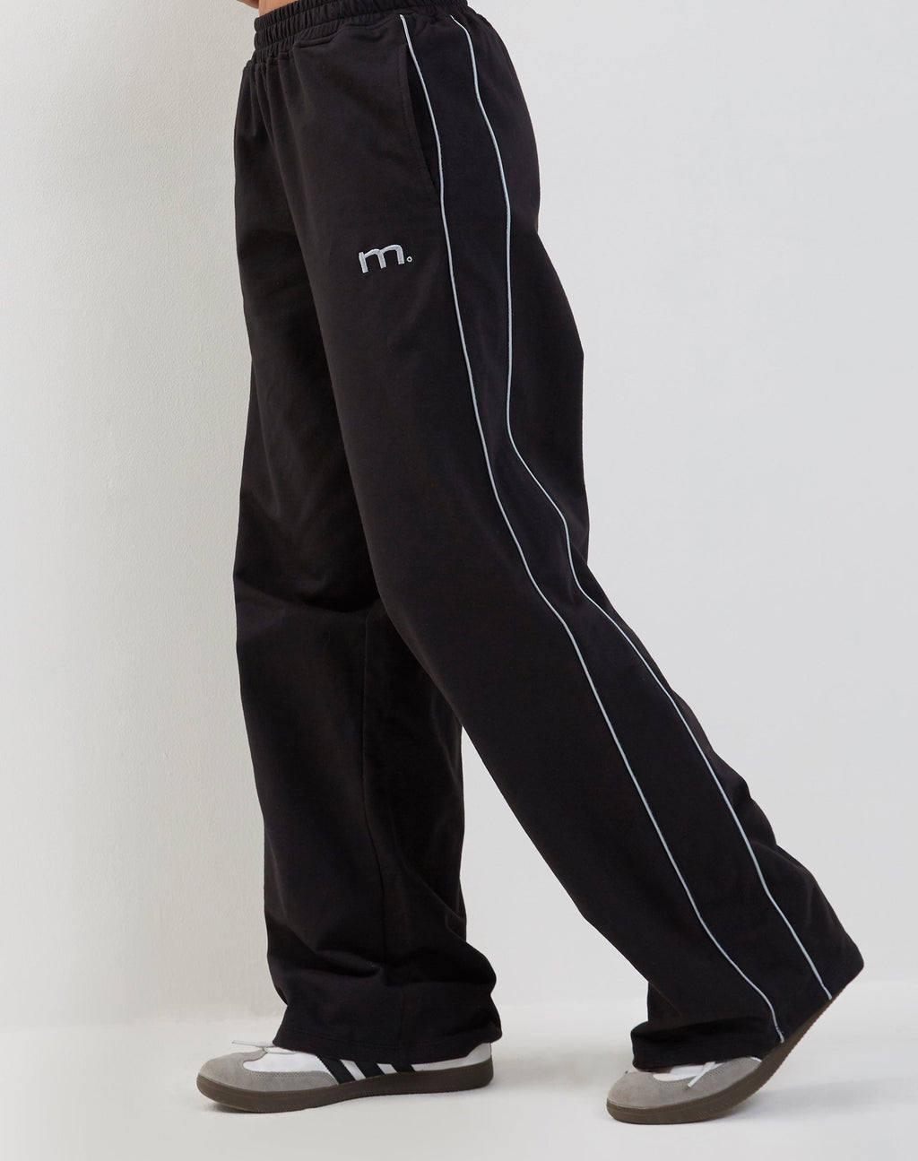 Jogger a gamba larga Benton in nero con profili grigio scuro e ricamo "M".