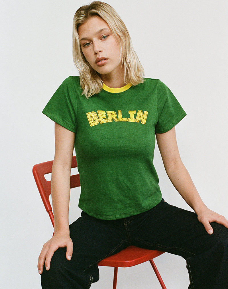 Top Sakha Boxy in verde olmo con rilegatura gialla e stampa berlinese