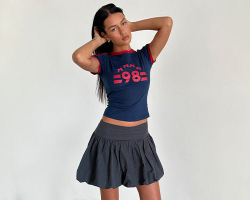 immagine di Salda Tee in Navy con bordino rosso Adrenaline e logo '98' e Kiyowo Puffball Mini Skirt in grigio antracite
