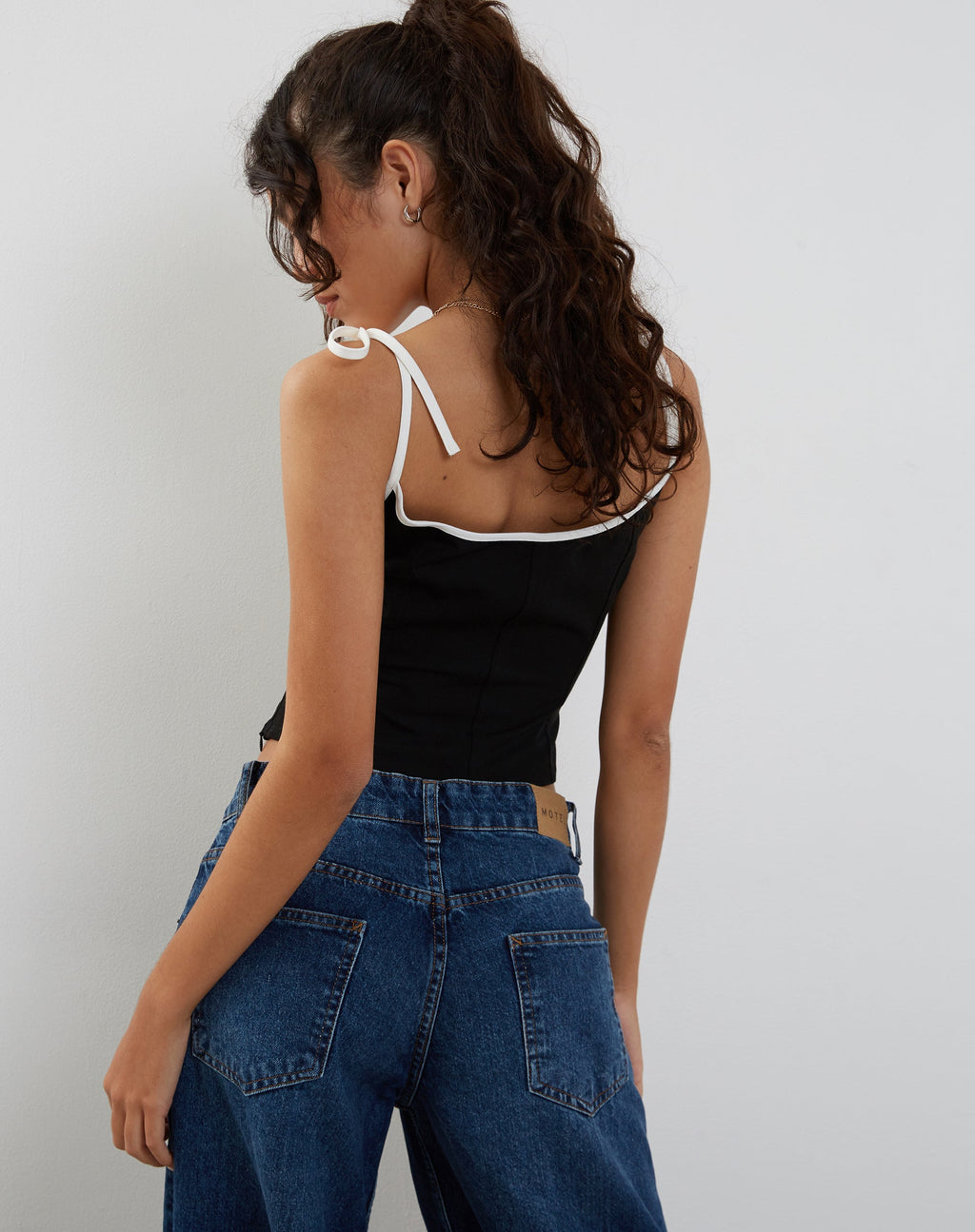 Top corsetto Kiona in nero con bordatura bianca
