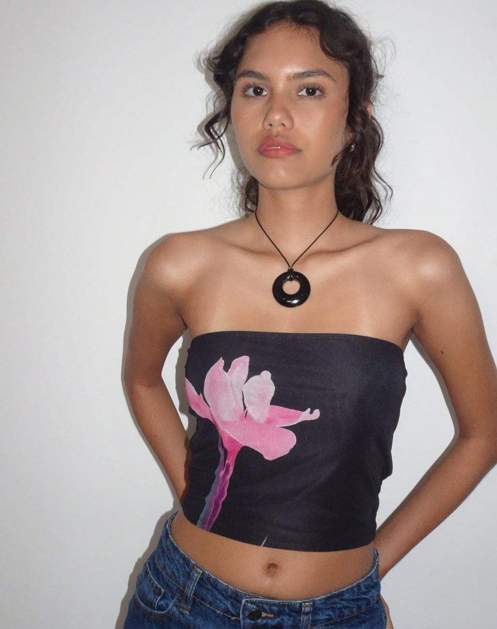 Top a fascia Shae nero con fiori rosa
