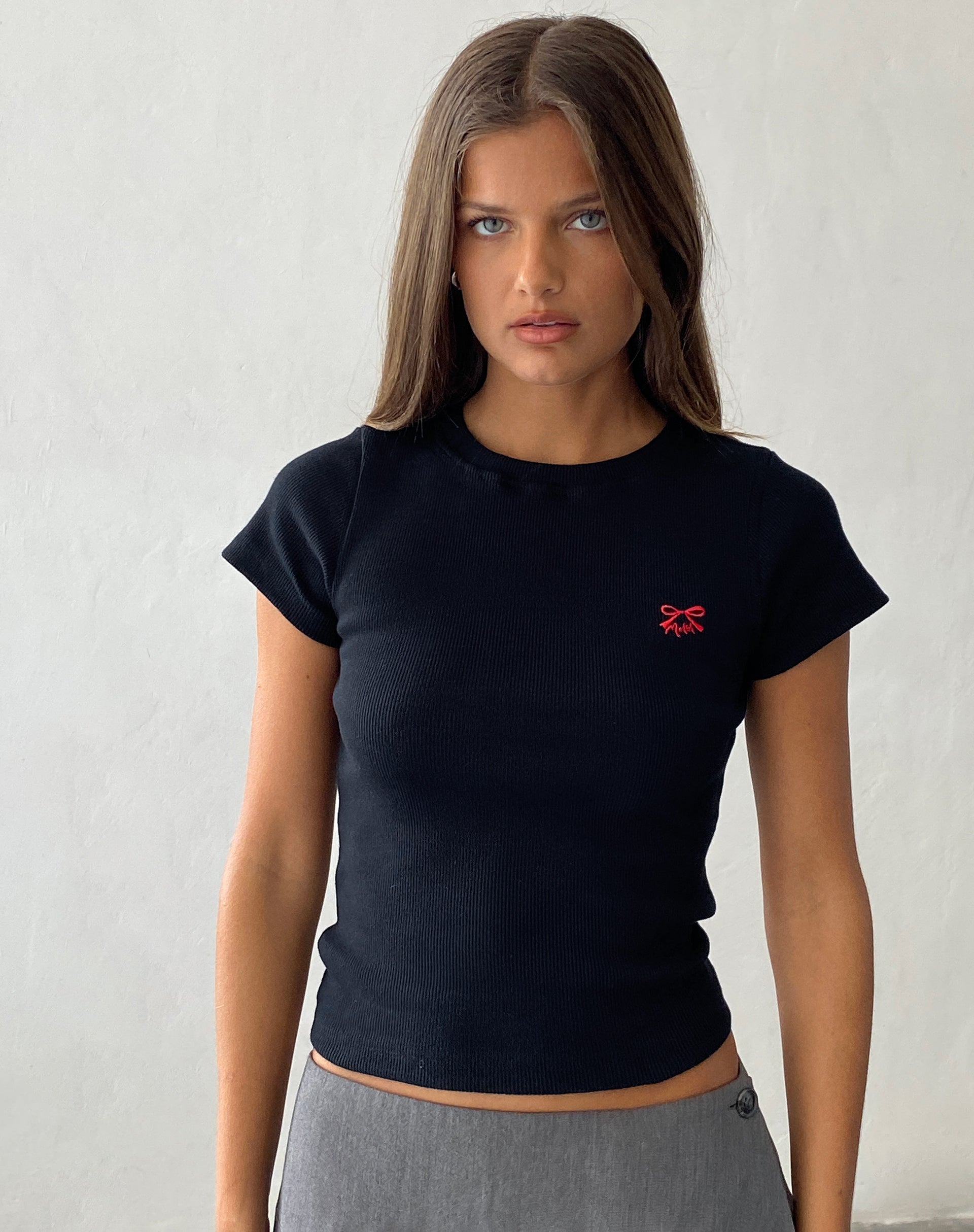 Immagine di Suti Tee a coste in nero con ricamo a fiocco rosso M