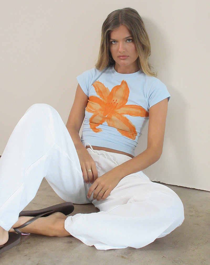 Immagine di Tiona Tee in blu con fiore dipinto di arancione