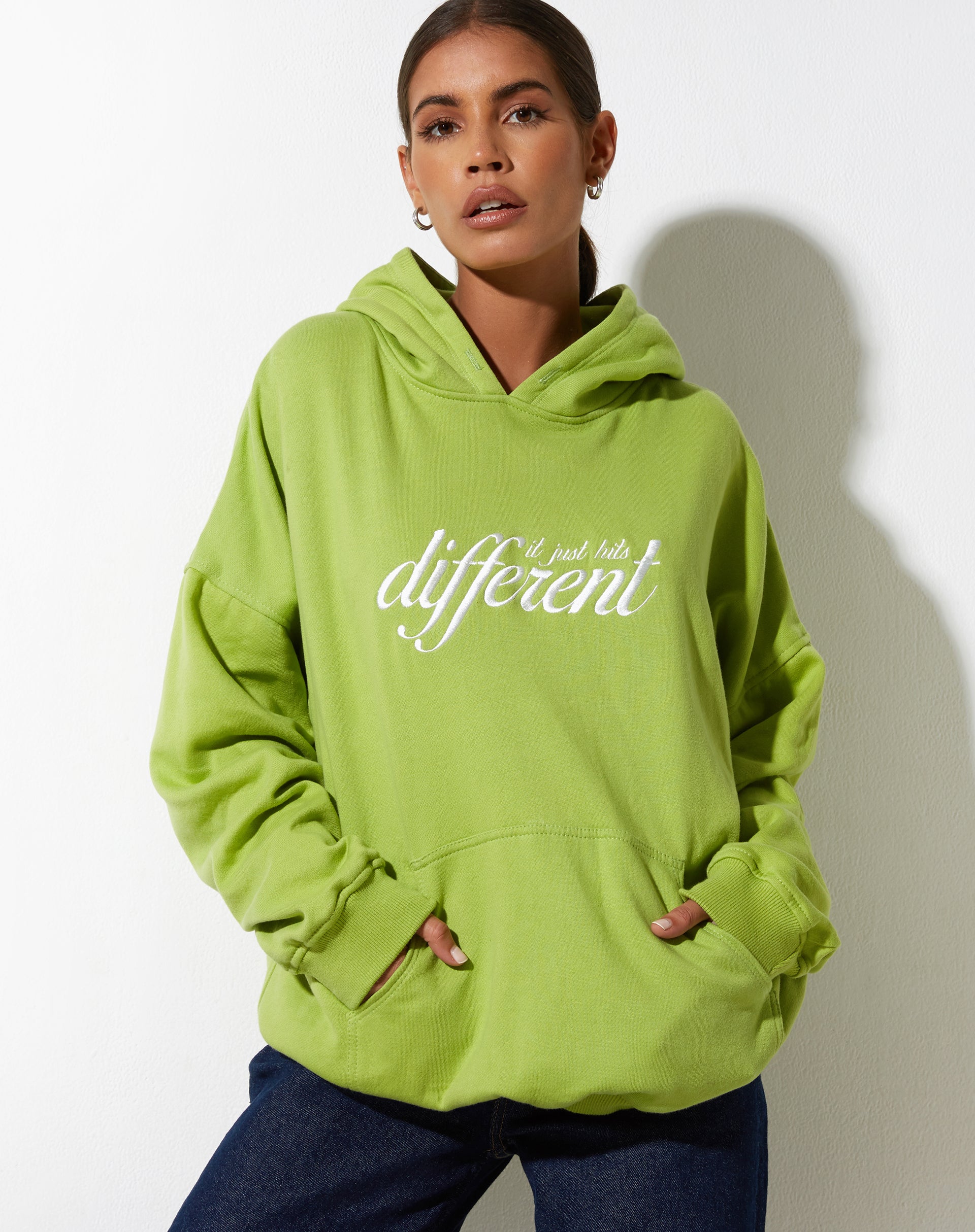 immagine della felpa con cappuccio oversize in verde foglia con diversi ricami in bianco